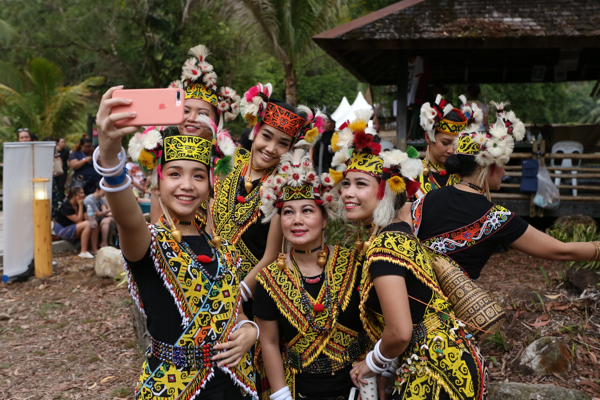 Women in Orang Ulu beaded dress taking a selfie at a festival